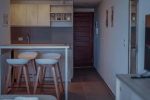 a kitchen with two bar stools and a counter at Gente del Sur - Buena Vista in Ushuaia +14 photos