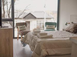 a bedroom with a bed with two chairs and a window at Gente del Sur - Buena Vista in Ushuaia