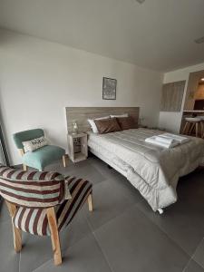 ein Schlafzimmer mit einem großen Bett und einem Stuhl in der Unterkunft Gente del Sur - Buena Vista in Ushuaia
