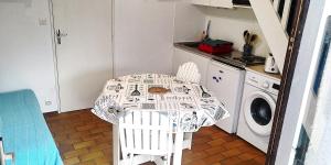 a kitchen with a table and a washing machine at Maisonnette 2 pièces Mezzanine 4 pers avec piscine extérieure chauffée ADELA in Guidel