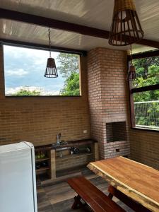 a kitchen with a table and a sink and a window at Casa de terra extended in Alter do Chao