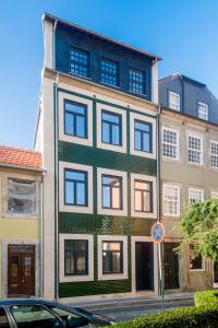 a tall building with blue windows on a street at Domum in Porto