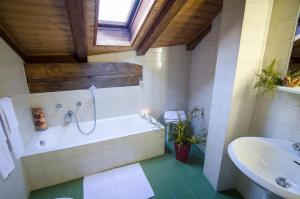 a bathroom with a tub, sink and toilet at Hotel Crimea in Chiavenna