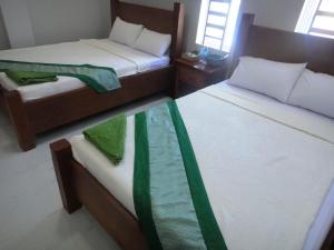 a bedroom with two beds and a glass table at Marany Guesthouse in Kampot