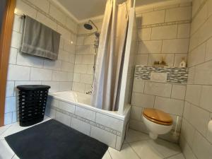 a bathroom with a tub and a toilet and a shower at Ferienwohnung 3 Schweizer in Fützen