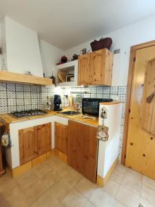 a kitchen with wooden cabinets and a white refrigerator at Casa vacanze Valentina in Campo di Giove