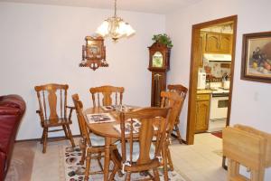 una sala da pranzo con tavolo, sedie e orologio di 23 Tomisa Lane a Hot Springs Village Altre 15 foto