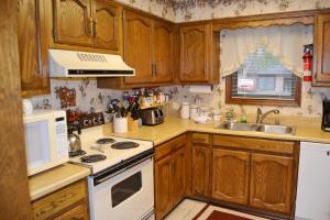 una cucina con armadi in legno e un piano cottura bianco con forno di 23 Tomisa Lane a Hot Springs Village