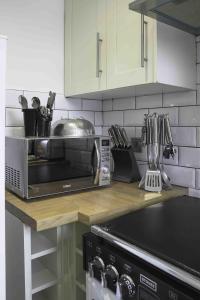 a kitchen counter with a toaster oven and a microwave at Strath Apartment in Strathaven +27 photos