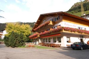 a building with tables and chairs in front of it at Hotel & Residence Sylvanerhof in Chiusa