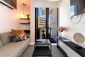 a living room with a couch and a table at Flamingo 407 - Central Prime Sea Point Apartment in Cape Town