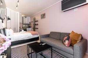 a living room with a couch and a bed at Flamingo 407 - Central Prime Sea Point Apartment in Cape Town +7 photos