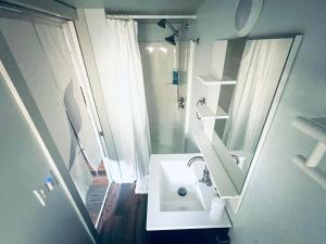 ein weißes Badezimmer mit Waschbecken und Spiegel in der Unterkunft Charming Romantic Lakefront Cottage or Guest Room Depending on Availability Near Golf in Anderson