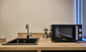 a microwave sitting on a counter next to a sink at sleep1c in Hamburg +10 photos