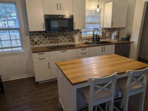 a kitchen with a wooden counter and a kitchen island at Pet Friendly Sleeps 9 HighSpeed WiFi 500MBPS Plus in Fresno