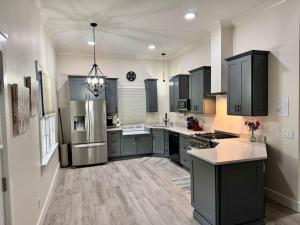 a kitchen with gray cabinets and a refrigerator at Newest Cottage Downtown. Pet Yes in Beaufort