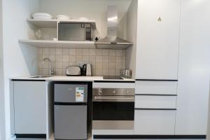 una cucina con lavello e fornello di The Rose 704: Top Floor Modern Studio Apartment a Città del Capo