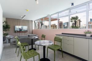 un ristorante con sedie, tavoli e finestre verdi di The Rose 704: Top Floor Modern Studio Apartment a Città del Capo