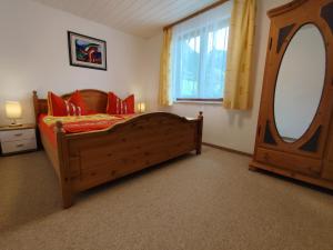 a bedroom with a wooden bed and a large mirror at Haus Daheim in Bad Hindelang