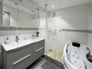 a bathroom with a shower and a sink and a tub at Chez Vélia Grand 4 pièces, parking privé et emplacement idéal in Strasbourg