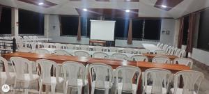a lecture hall with white chairs and a screen at Hotel y Restaurante Villa Quetzaly in Yalpemech