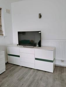 a white entertainment center with a flat screen tv on it at Budget-Friendly 4-Bedroom House in Swansea - Ideal for Travelers in Swansea
