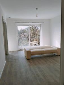 a large white room with a couch in front of a window at Budget-Friendly 4-Bedroom House in Swansea - Ideal for Travelers in Swansea