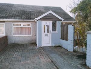 a house with a white door and a fence at Budget-Friendly 4-Bedroom House in Swansea - Ideal for Travelers in Swansea
