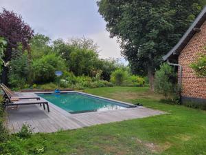 einen Pool im Garten mit Picknicktisch in der Unterkunft ferme de caractère avec piscine et cheminée in Sainghin-en-Mélantois