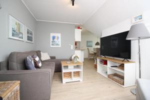 a living room with a couch and a flat screen tv at Ort Lemkenhafen Ostseeperle in Fehmarn