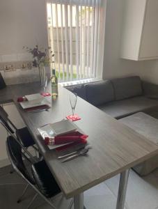 a wooden table with a wine glass on top of it at 5 bedroom ensuite spacious house in Bilston