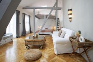 a living room with a white couch and a bed at Wenceslas Square Residence in Prague +108 photos