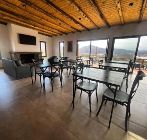 a dining room with tables and chairs and a fireplace at Casa del Plata Lodge in Potrerillos