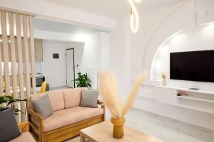 a living room with a couch and a tv at Cem's Luxury Apartment in Xanthi