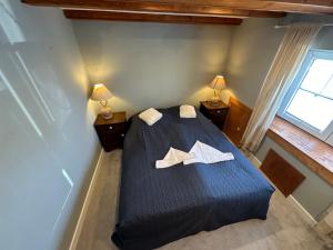 a bedroom with a blue bed with two white towels at Little Blue Cottage #9 in Fehmarn