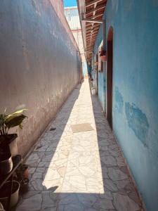 Un callejón con un edificio azul y asfalto. en Casa Caragua, en Caraguatatuba