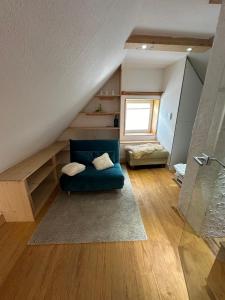 ein Wohnzimmer mit einem blauen Sofa im Dachgeschoss in der Unterkunft Little Blue Cottage #7 in Fehmarn