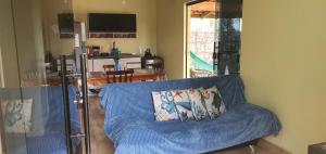 a living room with a blue couch with two pillows at Casa de Praia- Village Dunnas- Bal. Gaivota-SC in Balneário Gaivotas