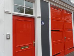 
a red door in a building with windows at MAFF Top Apartment in The Hague
