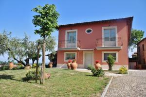 a pink house with flower pots in front of it at B&B Il Canto del Gallo in Casole dʼElsa