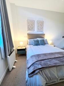 a bedroom with a large bed with two lamps on it at Luxury studio with super fast WiFi gated development in London