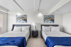 two beds sitting next to each other in a bedroom at Stunning Sunsets and SpaceX Views in South Padre Island +24 photos