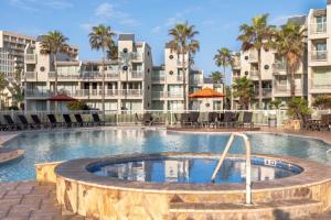 a large swimming pool with buildings in the background at Stunning Sunsets and SpaceX Views in South Padre Island