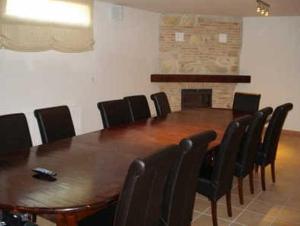 una sala de conferencias con mesa de madera y sillas en Finca Rincón de la Vega, en Los Cortos