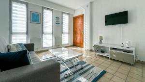 a living room with a couch and a tv at Studio vue mer in Trévou-Tréguignec