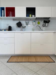 Una cocina con gabinetes blancos y un fregadero. en Elysium Etna Rooftop, en Fiumefreddo di Sicilia