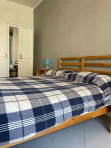Un dormitorio con una cama con una manta de cuadros azul y blanco en Elysium Etna Rooftop, en Fiumefreddo di Sicilia