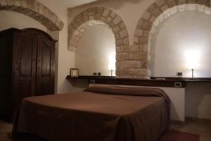 a bedroom with a bed and two arched windows at Villa Sant' Andrea in Gubbio