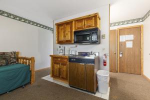 Una pequeña cocina con fregadero y microondas. en Pelican Lakes Motel, en Breezy Point 6 fotos más