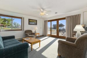 Una sala de estar con un sofá y sillas y una mesa. en Pelican Lakes Motel, en Breezy Point